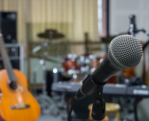 Primer plano de un micrófono en una sala de grabación de una banda de música
